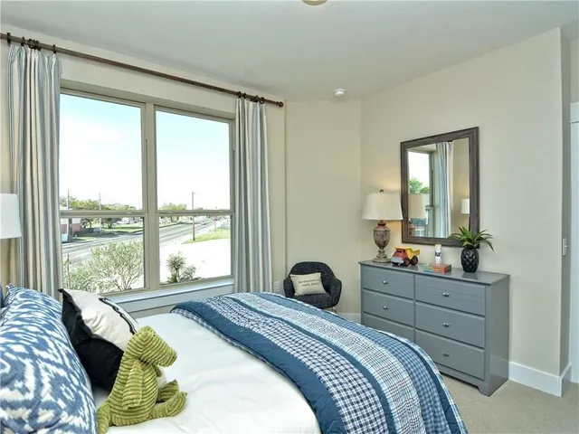 a bedroom with a bed and large windows