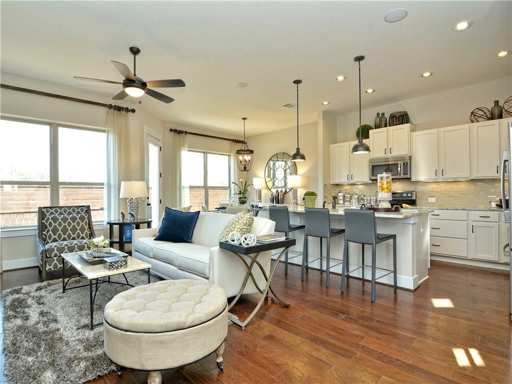 12504 Red Sparrow Street, Unit 1 Austin, TX 78729 - Photo 4 of 22 a living room with couches a coffee table and chairs with a dining table