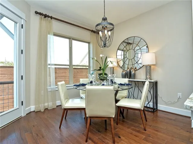 a view of a dining room with furniture a chandelier and wooden floor