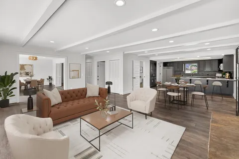 a kitchen with kitchen island granite countertop wooden floors white appliances and cabinets