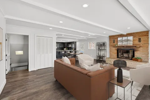 a kitchen with stainless steel appliances granite countertop a stove top oven a sink dishwasher a microwave oven and a refrigerator with wooden floor