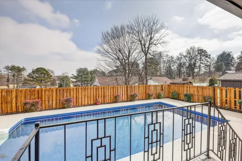 a view of a backyard with swimming pool and furniture