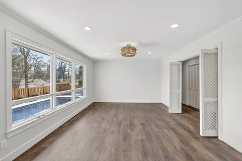 a view of empty room with wooden floor and a fireplace
