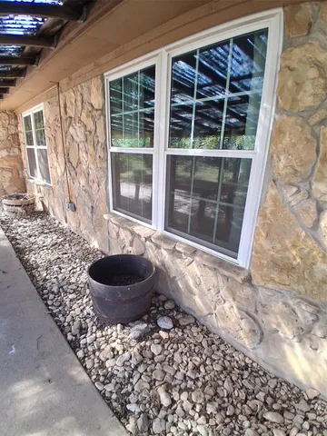 a room with a large window and a potted plant