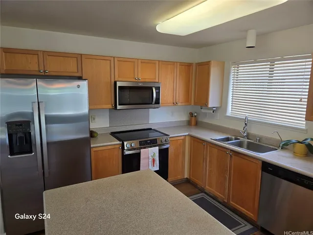 a kitchen with stainless steel appliances granite countertop a stove a sink dishwasher a refrigerator and a microwave oven