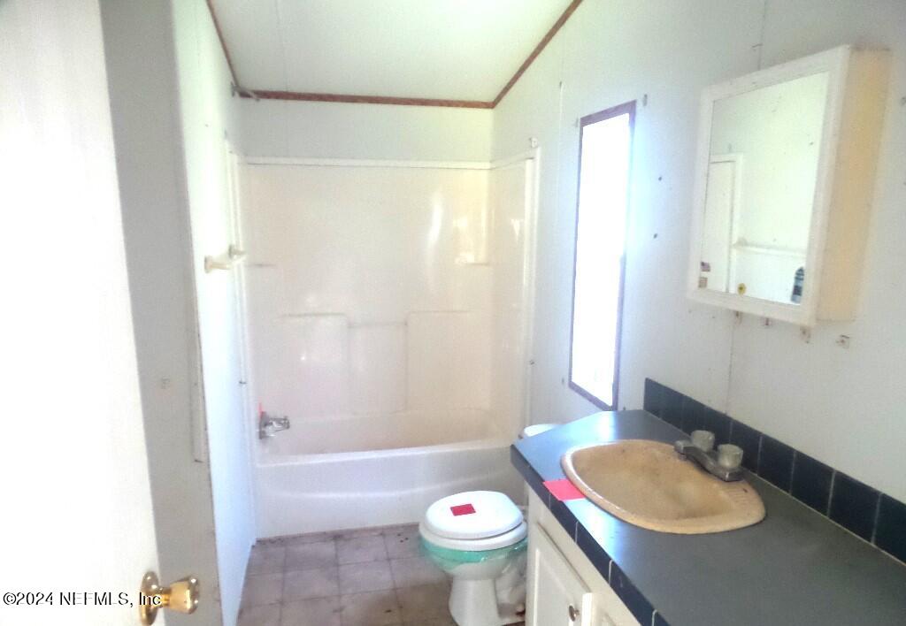 1831 Forbes Road, Unit 1 St. Augustine, FL 32092 - Photo 11 of 20 a bathroom with a sink a toilet and shower