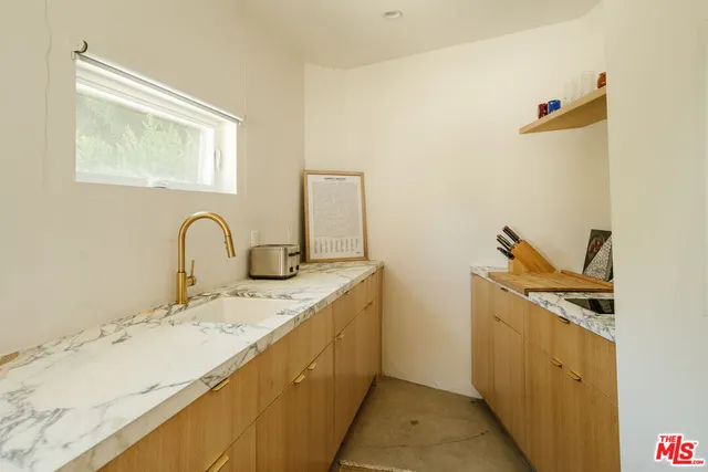 a bathroom with a granite countertop sink a toilet and a mirror