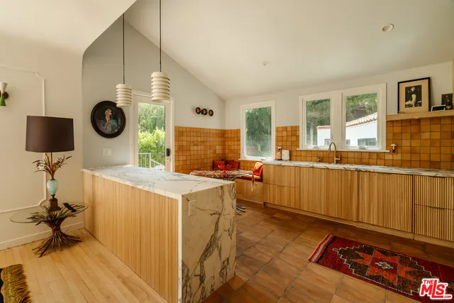 a living room with stainless steel appliances granite countertop a stove and a sink