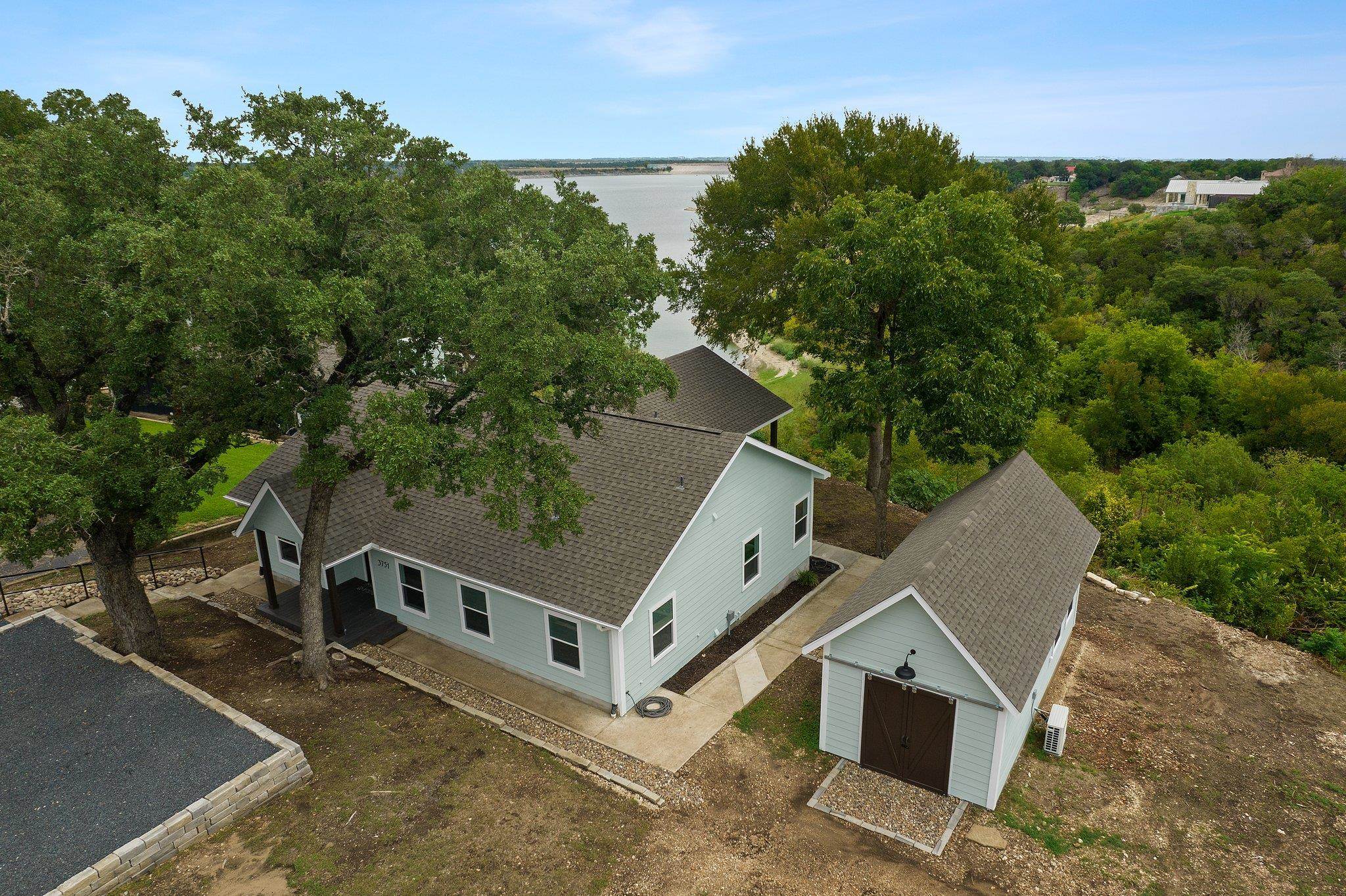 an aerial view of a house with a yard and trees