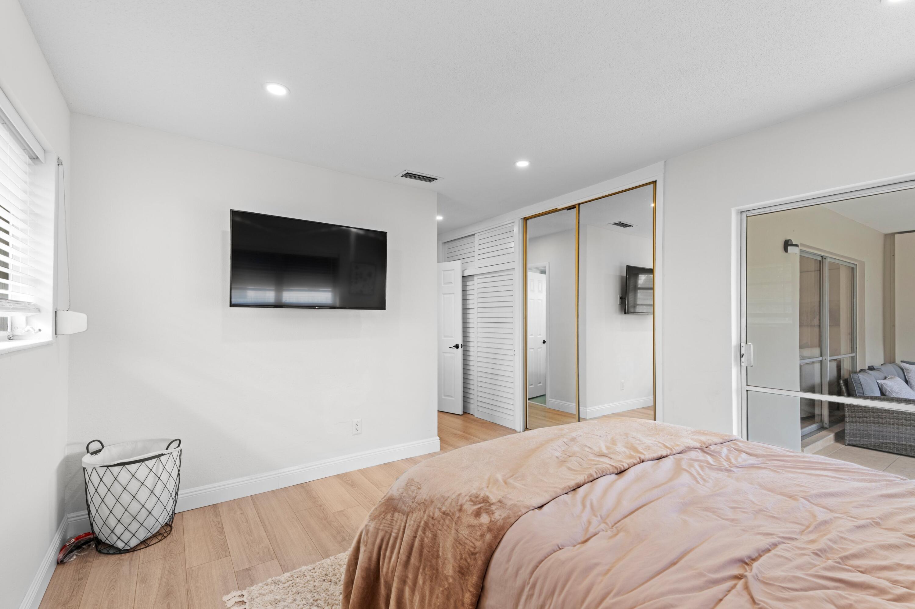 40 Southeast 13th Street, Unit B1 Boca Raton, FL 33432 - Photo 11 of 34 a bedroom with a bed and a flat screen tv