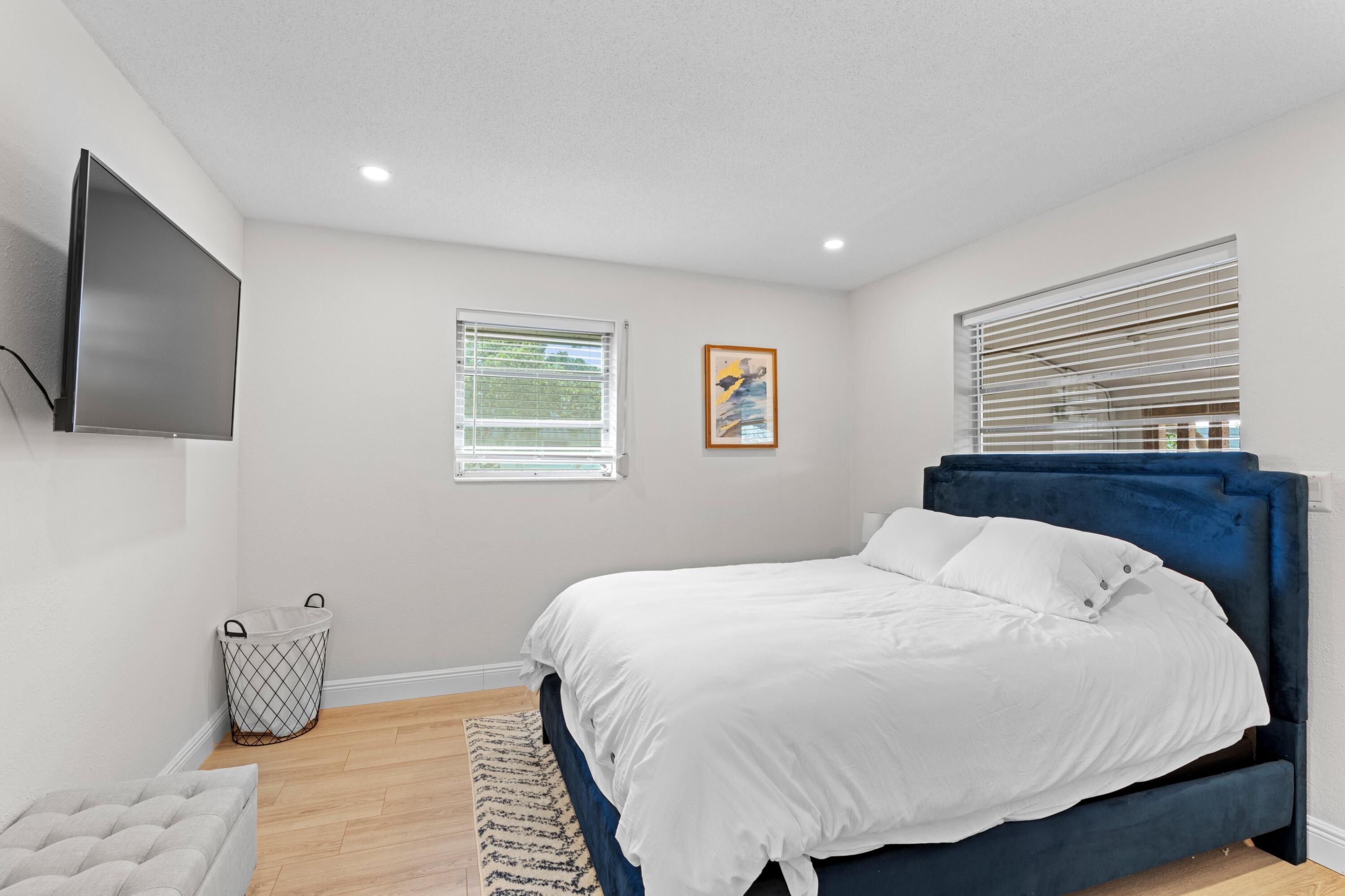 40 Southeast 13th Street, Unit B1 Boca Raton, FL 33432 - Photo 13 of 34 a bedroom with a bed and a flat screen tv