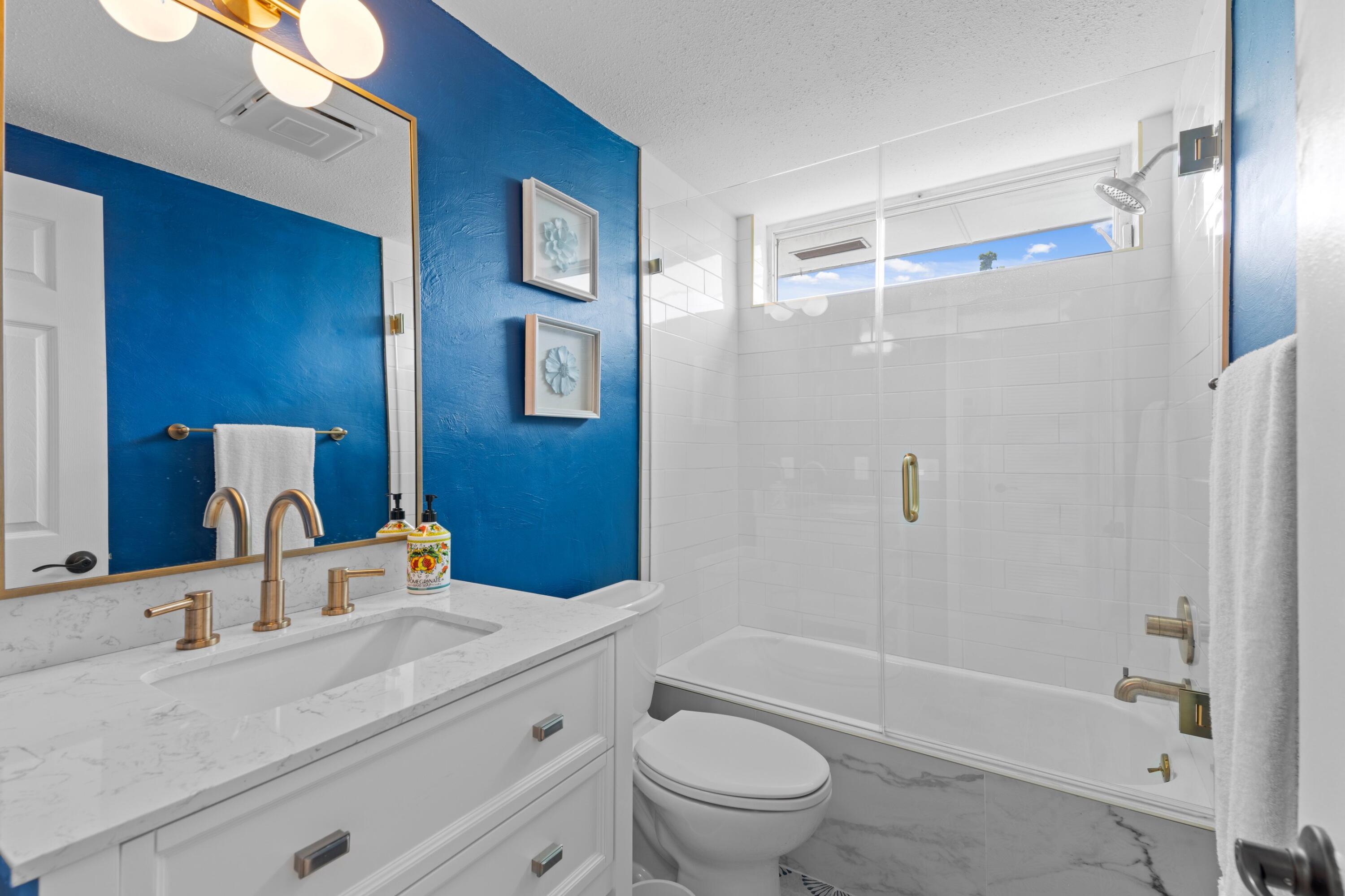 40 Southeast 13th Street, Unit B1 Boca Raton, FL 33432 - Photo 14 of 34 a bathroom with a sink a toilet a mirror a bathtub and shower