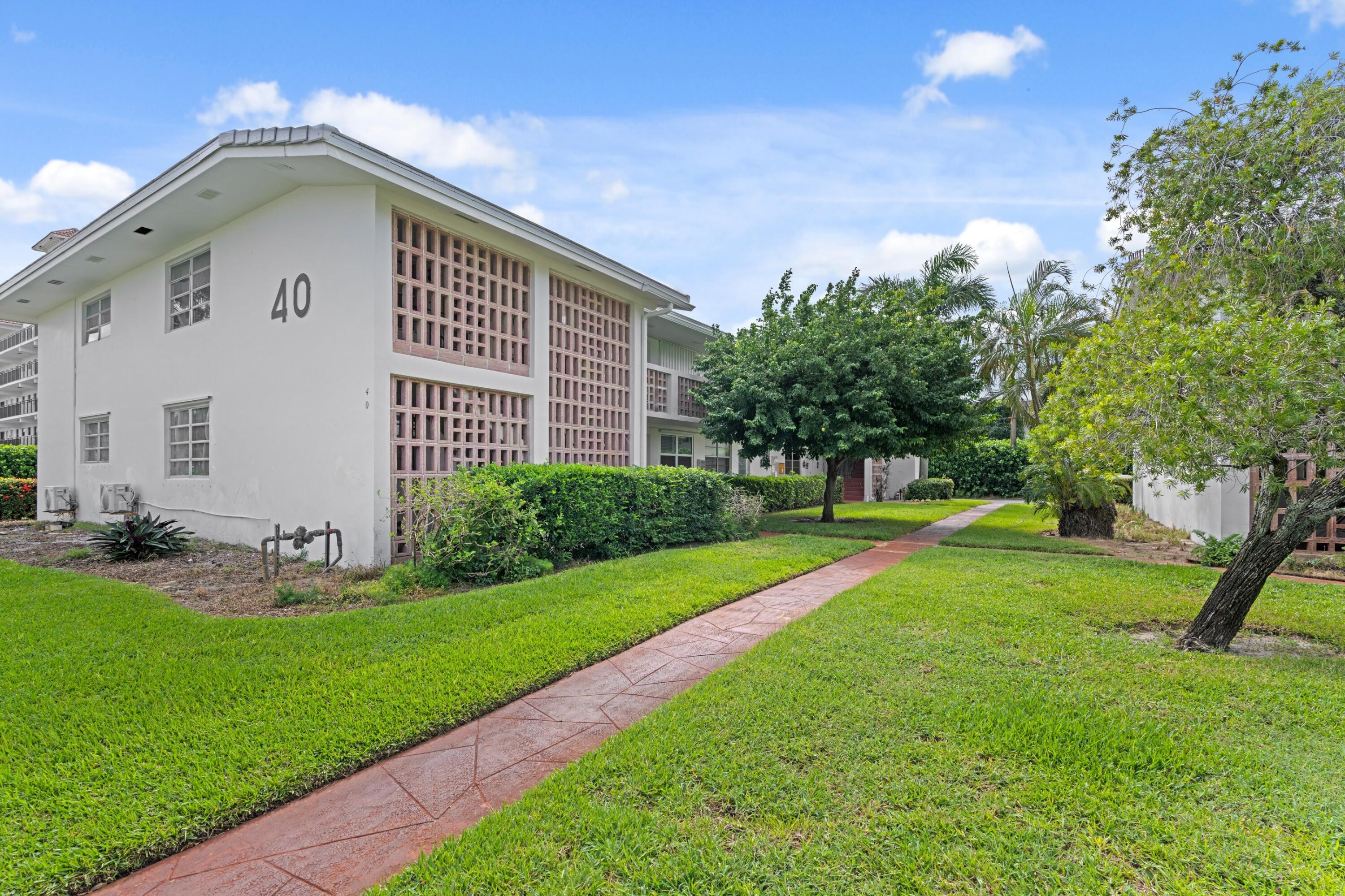 40 Southeast 13th Street, Unit B1 Boca Raton, FL 33432 - Photo 16 of 34 a front view of a house with a yard