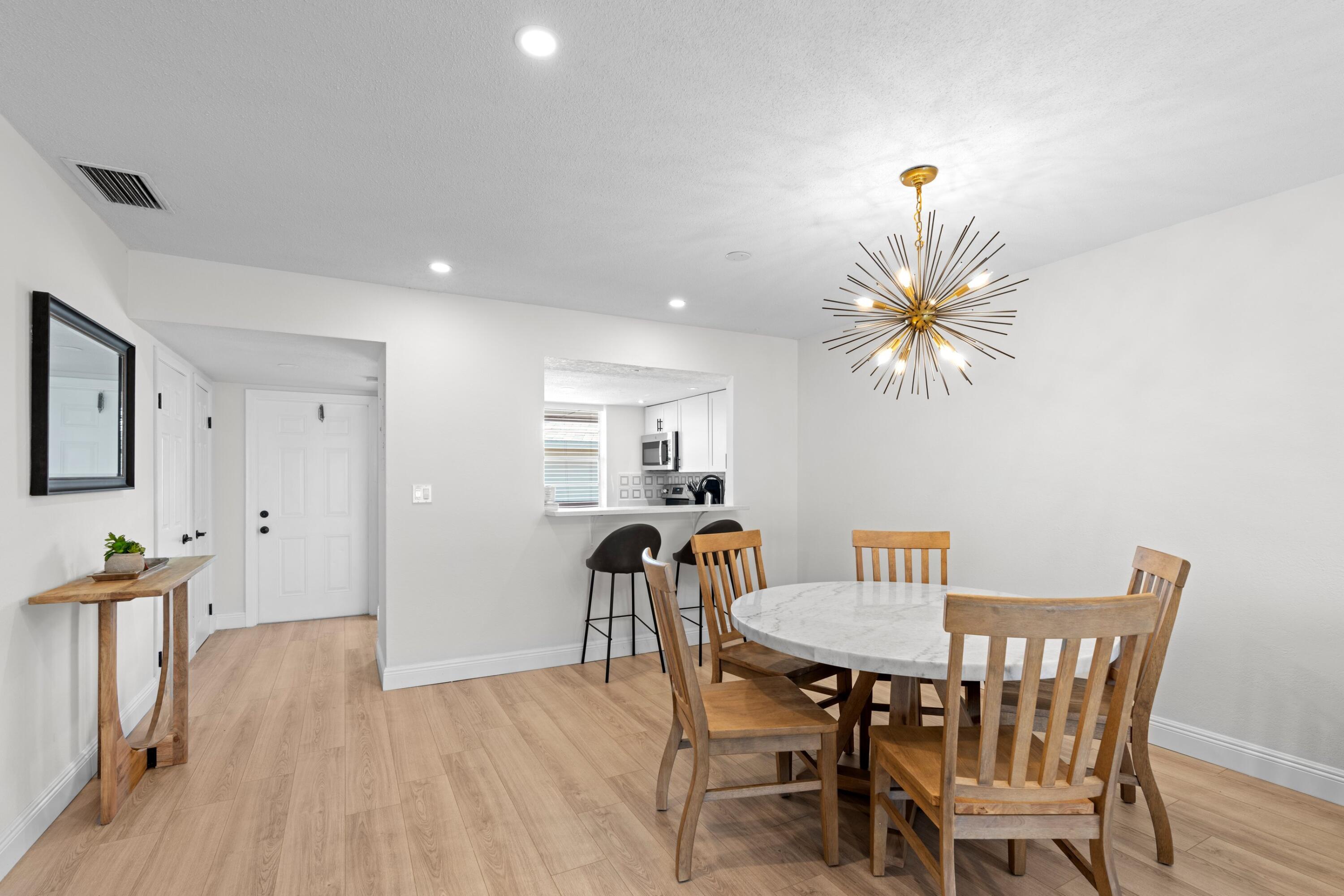 40 Southeast 13th Street, Unit B1 Boca Raton, FL 33432 - Photo 7 of 34 a view of a dining room with furniture and wooden floor