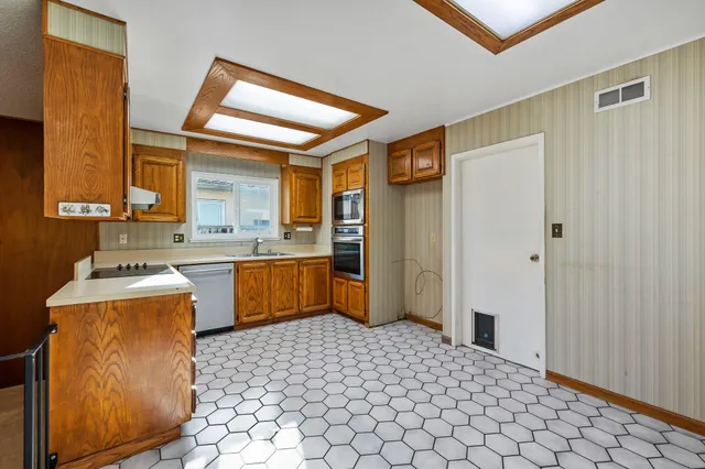 a kitchen with stainless steel appliances a sink and a refrigerator