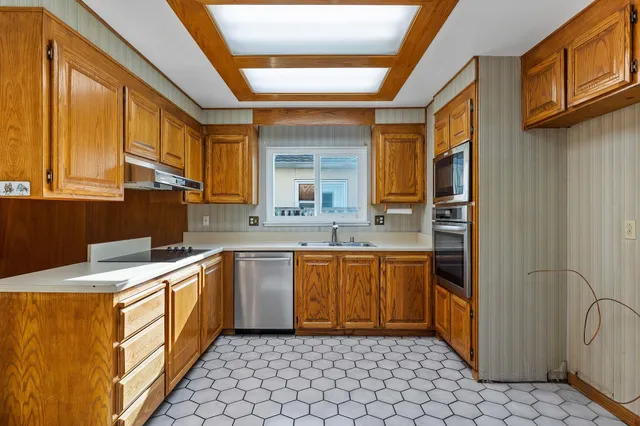 a kitchen with stainless steel appliances granite countertop a stove a sink and a refrigerator