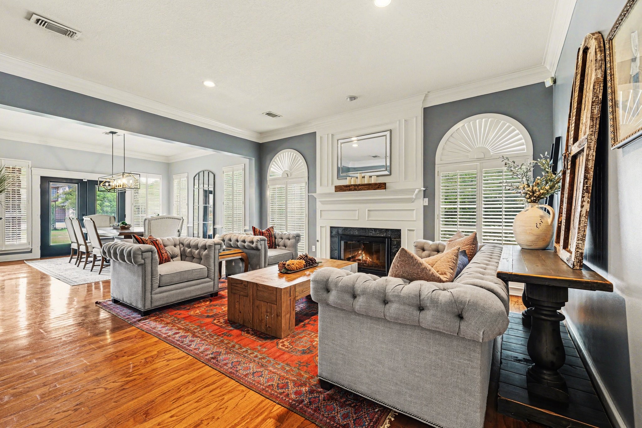 17519 Hawkin Lane Tomball, TX 77377 - Photo 12 of 48 Spacious sitting room featuring rich wood flooring, a cozy fireplace, and abundant natural light, all seamlessly flowing into the dining area.