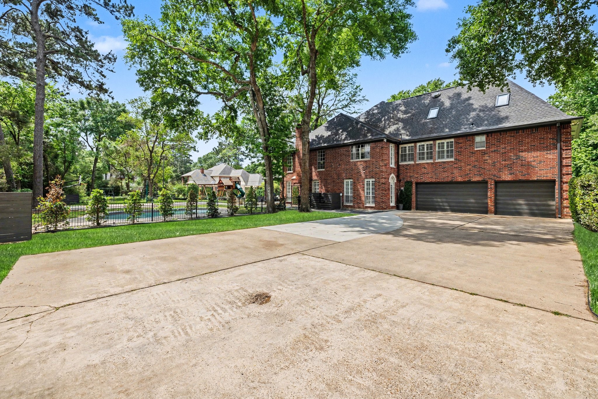 17519 Hawkin Lane Tomball, TX 77377 - Photo 4 of 48 Expansive driveway provides ample parking space & easy access, with a private backyard setting featuring a pool, basketball court, and mature trees.