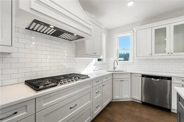 a kitchen with white cabinets and appliances