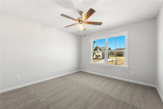an empty room with window and ceiling fan