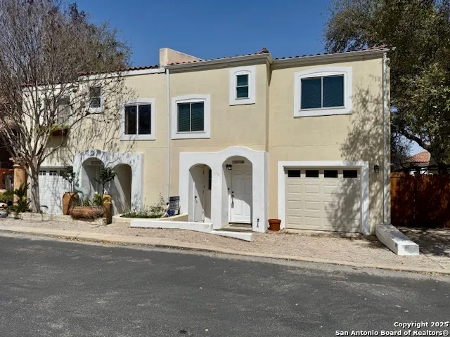 a view of a white house with a yard and large tree