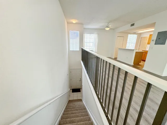 a view of a hallway with wooden floor and staircase