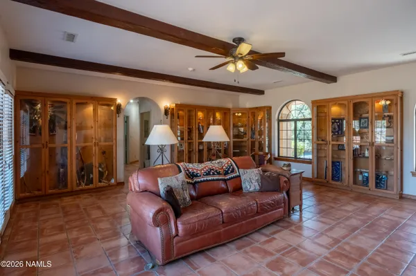a living room with furniture a flat screen tv and a window