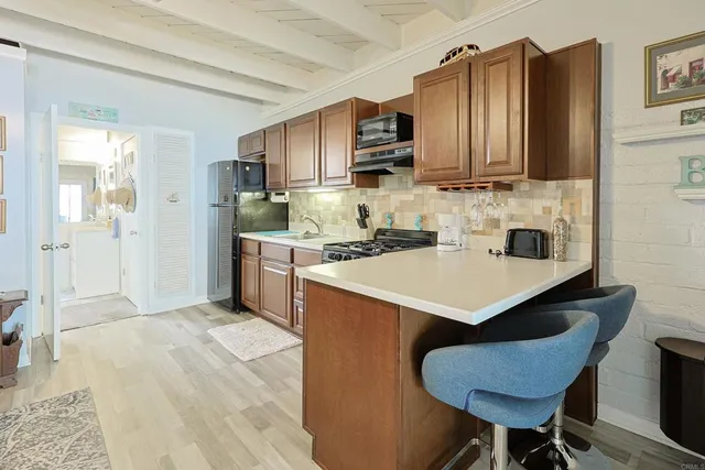 a kitchen with stainless steel appliances granite countertop a sink a microwave cabinets and wooden floor
