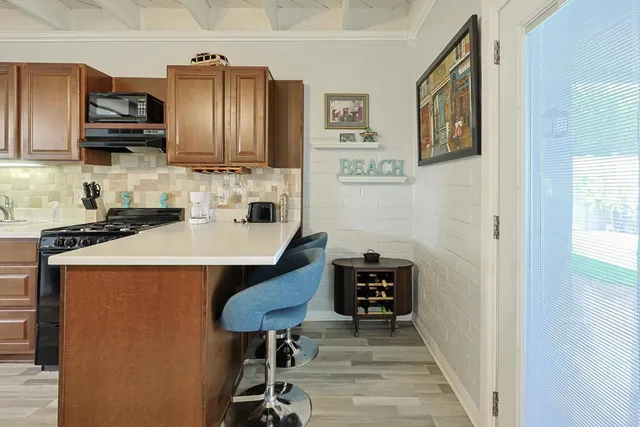 a kitchen with stainless steel appliances a sink a stove a microwave a counter top space and cabinets