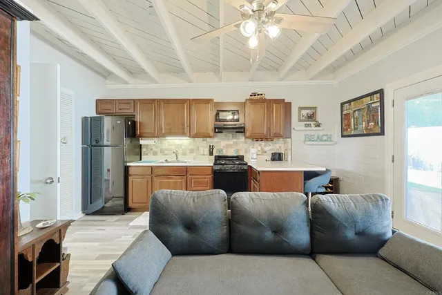 a living room with stainless steel appliances kitchen island granite countertop furniture and a kitchen view