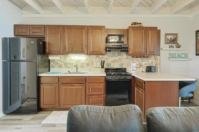 a kitchen with stainless steel appliances granite countertop a refrigerator a stove a sink and a refrigerator