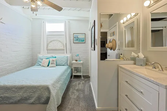 a en suite bathroom with a granite countertop sink and a mirror