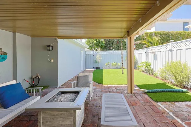 a view of a patio with table and chairs with wooden floor and fence