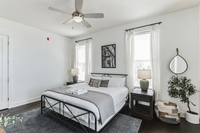 a bedroom with a bed a chandelier and a window
