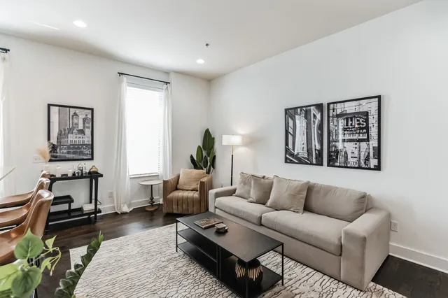 a living room with furniture a rug and a window