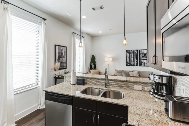 a kitchen with stainless steel appliances a sink and a refrigerator
