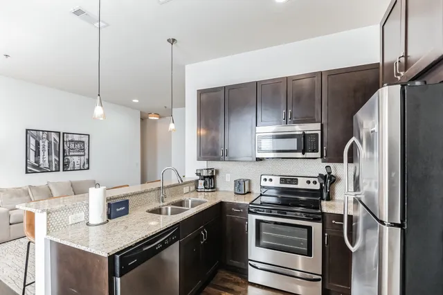 a kitchen with stainless steel appliances a sink stove and refrigerator