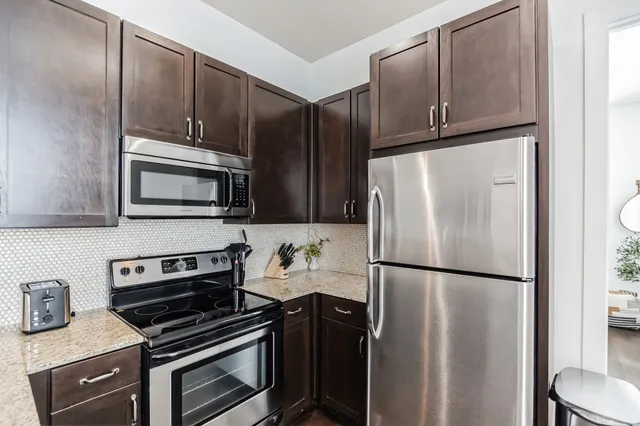 a kitchen with stainless steel appliances granite countertop a refrigerator stove and microwave