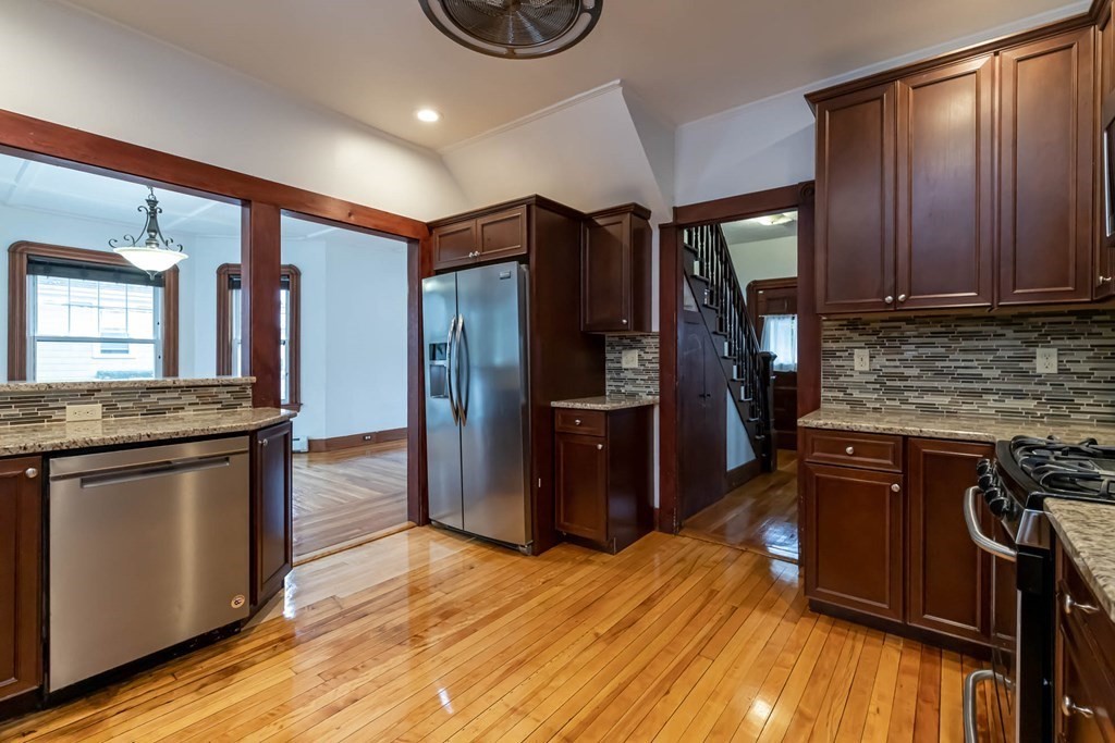 1 May Court Methuen, MA 01844 - Photo 8 of 40 a kitchen with stainless steel appliances granite countertop a refrigerator a stove and a wooden floors