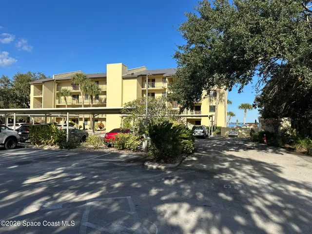 a view of car parked in front of yellow house