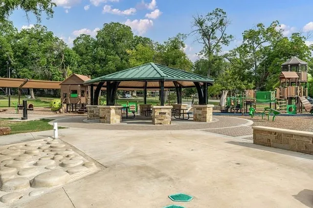 a view of a sign board with large trees