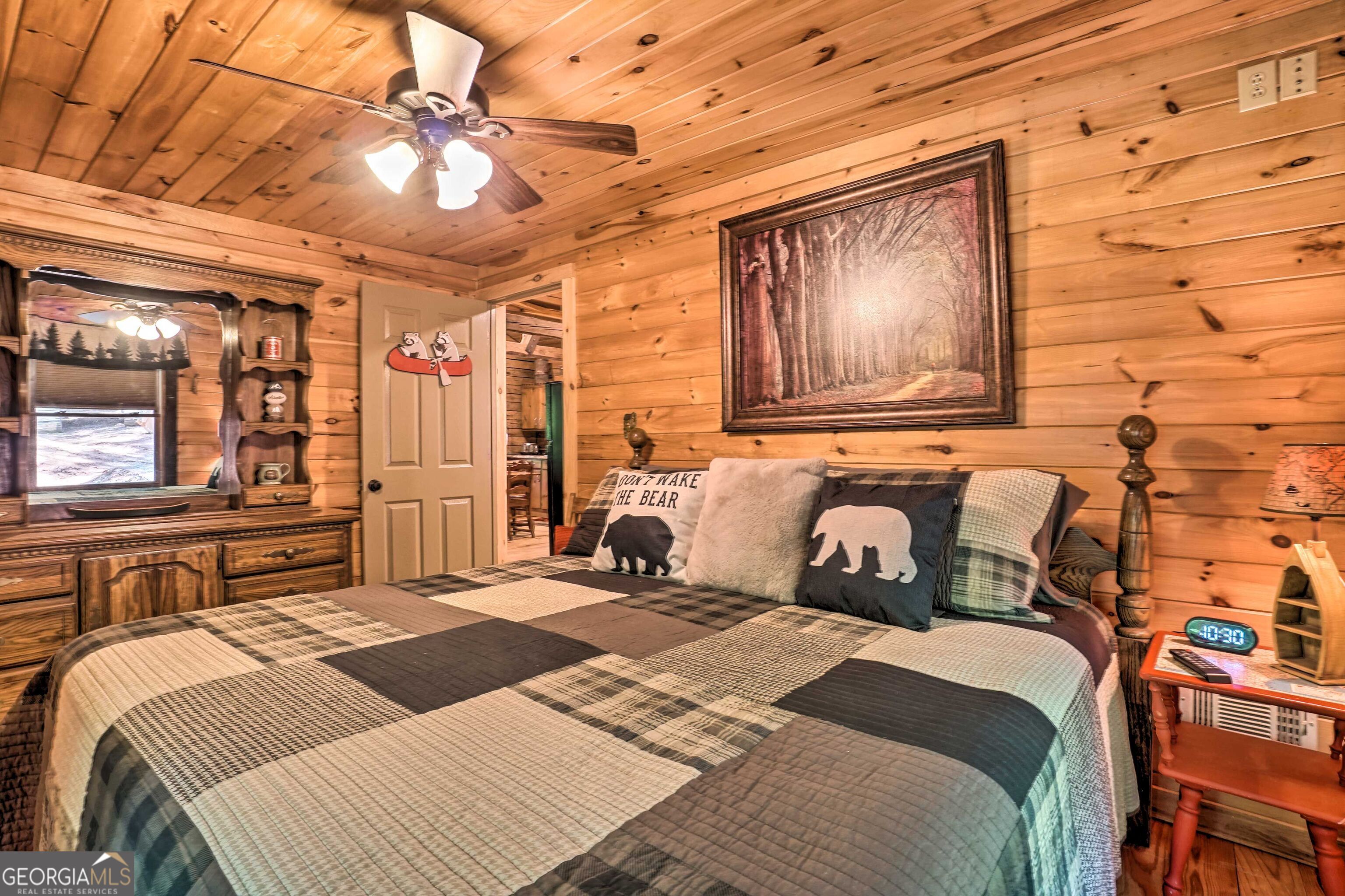 2183 Chimney Mountain Road Sautee Nacoochee, GA 30571 - Photo 17 of 28 a bedroom with a large bed and a chandelier