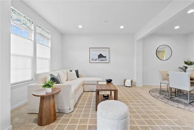 a living room with couches a coffee table and next to a window