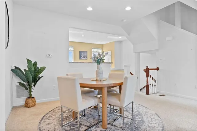 a dining room with furniture and potted plants