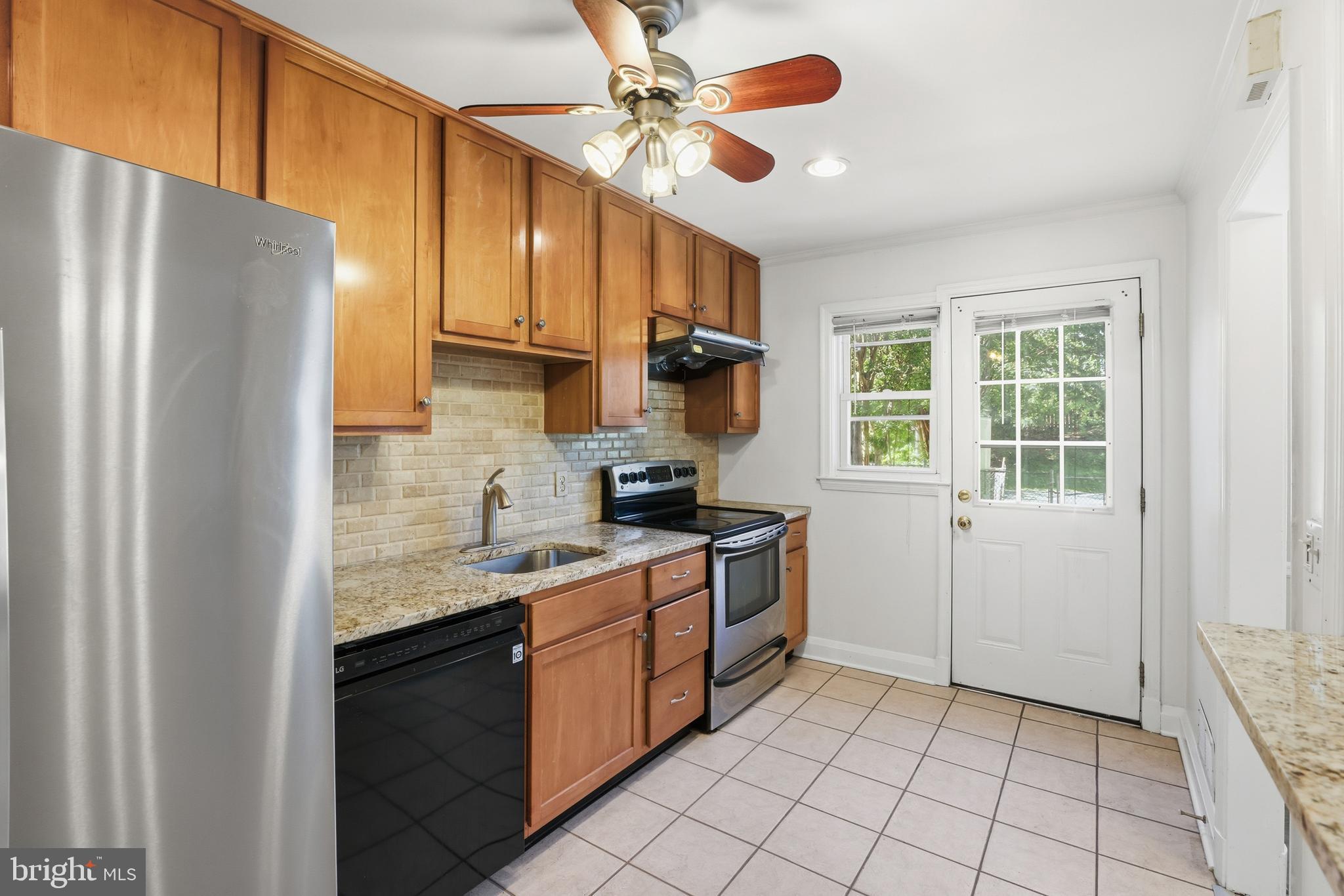 1002 Winsford Road Baltimore, MD 21204 - Photo 12 of 30 a kitchen with stainless steel appliances granite countertop a refrigerator a sink dishwasher a stove with wooden cabinets and floor