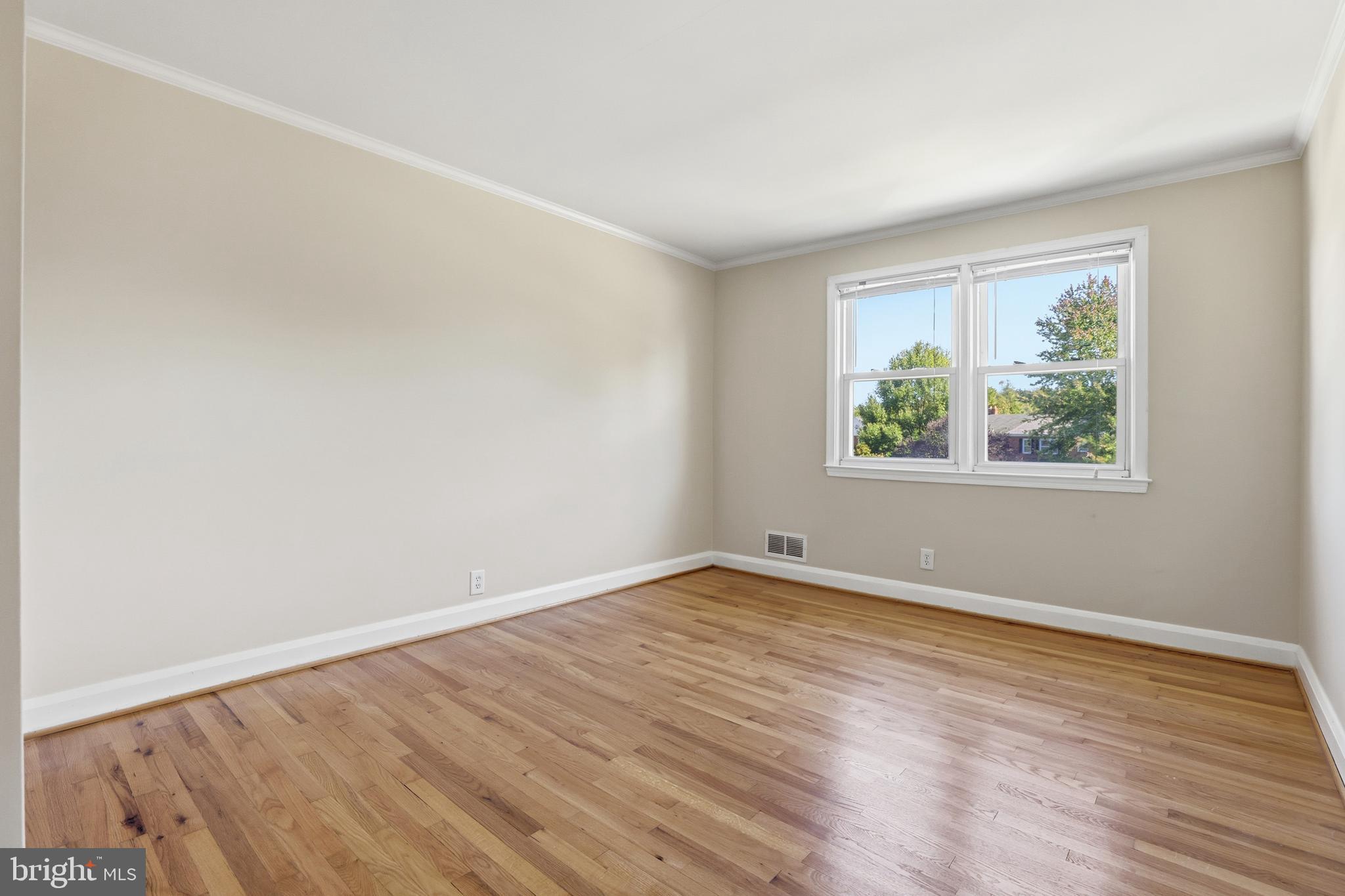 1002 Winsford Road Baltimore, MD 21204 - Photo 17 of 30 an empty room with wooden floor and window
