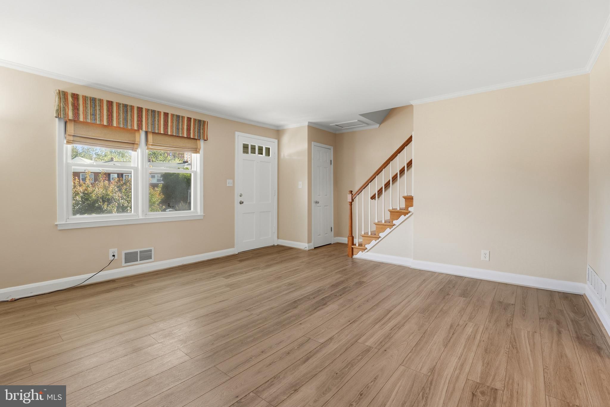 1002 Winsford Road Baltimore, MD 21204 - Photo 6 of 30 a view of an empty room with wooden floor and a window