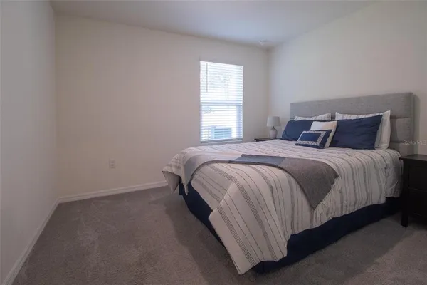 a spacious bedroom with a bed and window
