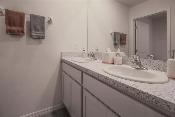 a bed sitting in a bedroom next to a bathroom sink