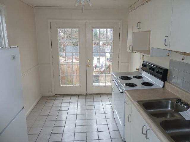2203 Courtland Road Northeast Roanoke, VA 24012 - Photo 2 of 10 a kitchen with a stove a sink and a refrigerator